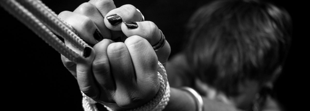 Black and white photo of hands gripping bondage rope – BDSM restraint concept from Playbox Store